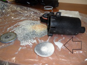 Забитый осушитель воздуха в разобранном виде: раскрошенный селикагель (стрелка на фото)
